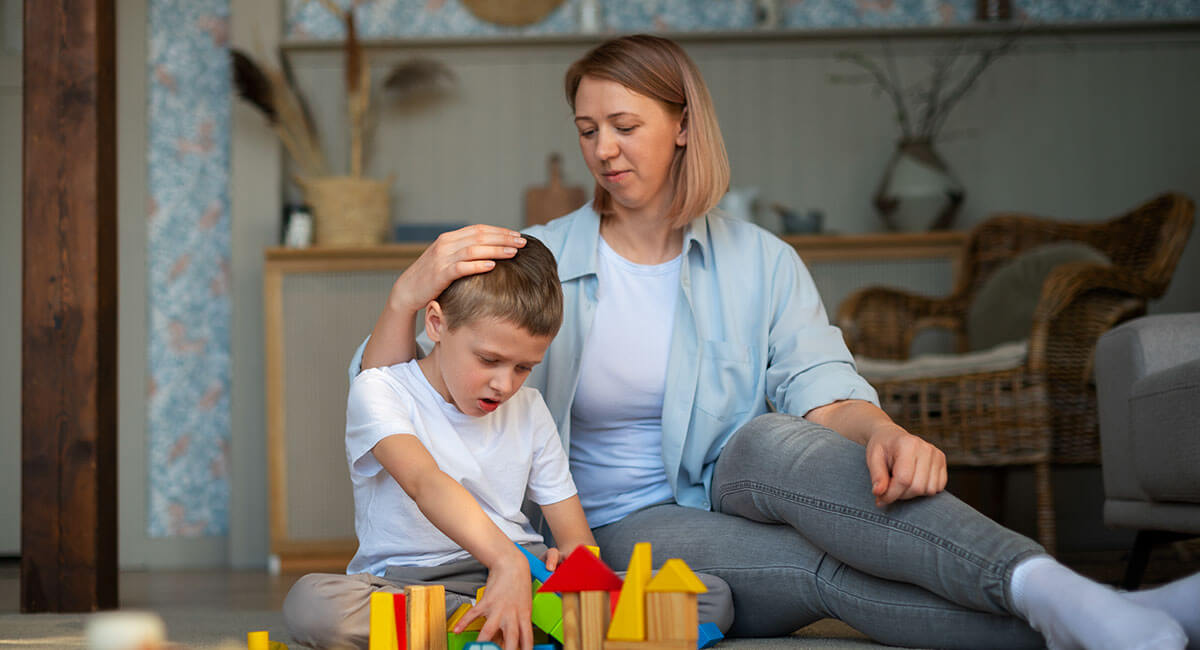 A mother observing a child with autism who indulges in play with objects.