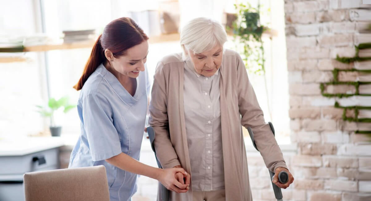 A respite care worker assisting a senior woman in reading a book