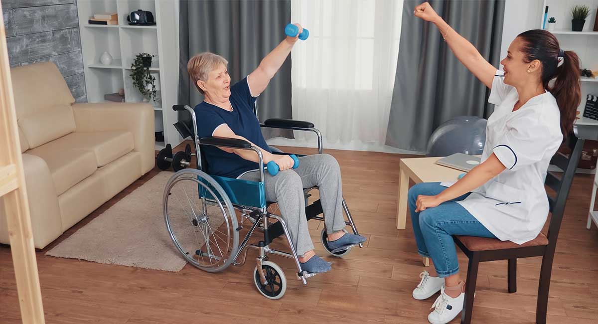 Elderly woman receiving rehabilitation therapy with the help of a caregiver