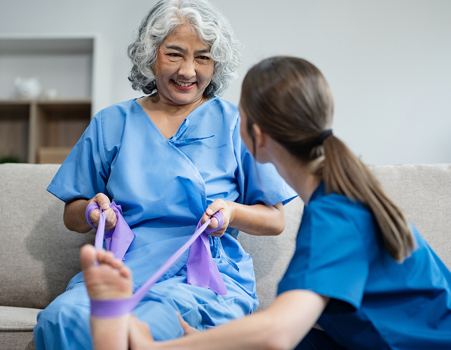 Care workers assist an elderly woman in the late stages of dementia