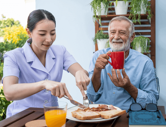 A caregiver providing food and nutritional needs for an elderly person
