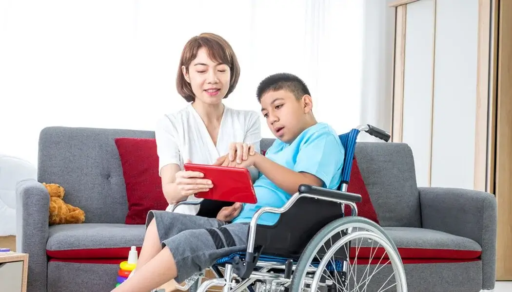A caregiver assisting a learning disabled child in reading a book